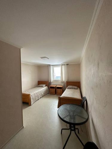 Cette chambre comprend deux lits, une table et une chaise. dans l'établissement Apartment, à Kovel