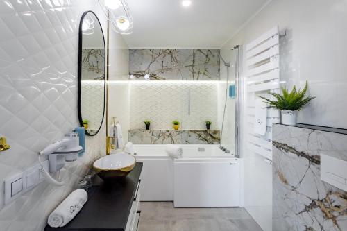 a white bathroom with a toilet and a sink at Q18 ApartHotel in Bydgoszcz