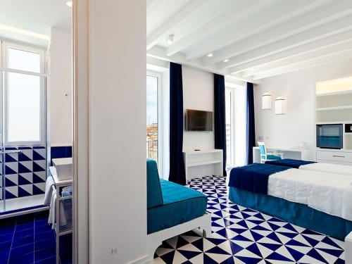 Cette chambre comprend un lit et un bureau. dans l'établissement Maison Blu - Intimate GuestHouse, à Sorrente