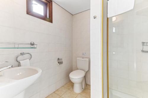 a white bathroom with a toilet and a sink at 2 bedroom Apartment Assia with communal pool, Aphrodite Hills Resort in Kouklia