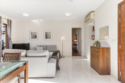 a living room with a couch and a table at 2 bedroom Apartment Assia with communal pool, Aphrodite Hills Resort in Kouklia