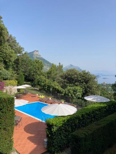 a swimming pool with two umbrellas and a swimming poolvisor at Il Casalino in Maratea
