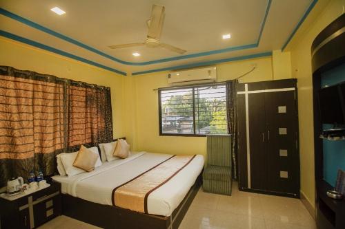 a bedroom with a bed and a window at Hotel Sundaram Palace in Siliguri