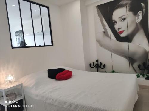 un lit blanc avec une grande photo d'une femme dans l'établissement Studio 551, Port Soleil au village naturiste, au Cap d'Agde