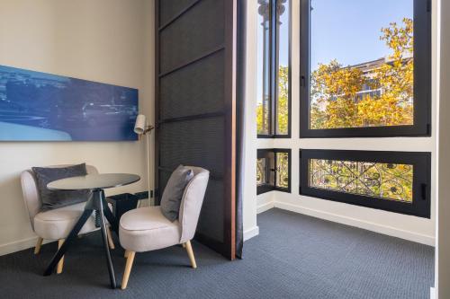 a room with two chairs and a table and windows at Sixtytwo Hotel in Barcelona