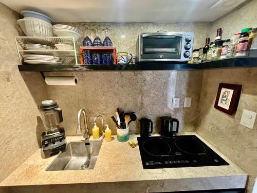 a kitchen counter with a sink and a microwave at Beachfront Hammock Heaven in Akumal