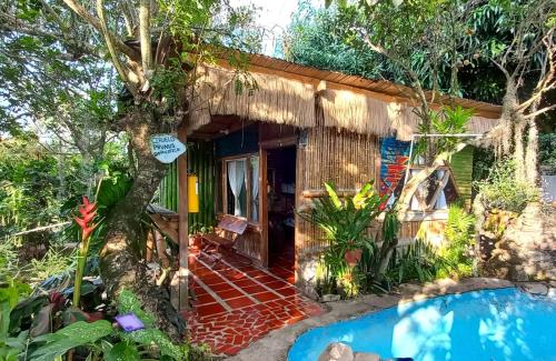 Villa Sonia Eco-Hostel في Gigante: كوخ أمامه مسبح