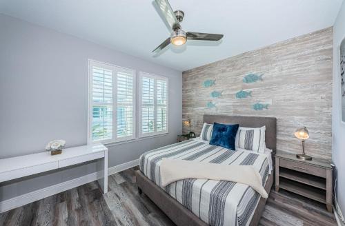 a bedroom with a bed and a ceiling fan at Tropical Treasure Beach Villa in St. Pete Beach