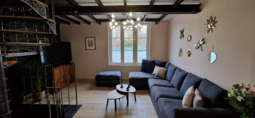a living room with a blue couch and a table at Bleautiful Joséphine - Maison de ville avec jardin in Fontainebleau