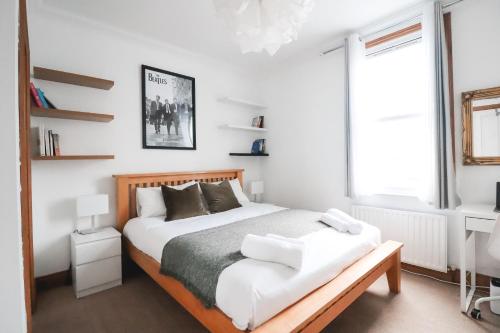 ein Schlafzimmer mit einem großen Bett und einem Fenster in der Unterkunft Fulham Rooms in London