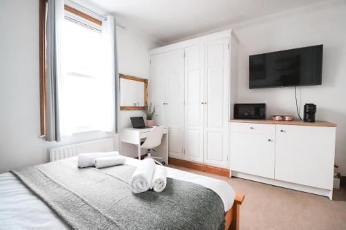 ein Schlafzimmer mit einem Bett mit Handtüchern darauf in der Unterkunft Fulham Rooms in London