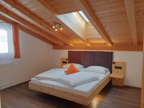 Cette chambre comprend un grand lit et un plafond en bois. dans l'établissement Ferienwohnungen Zeppenhof, à Santa Valburga