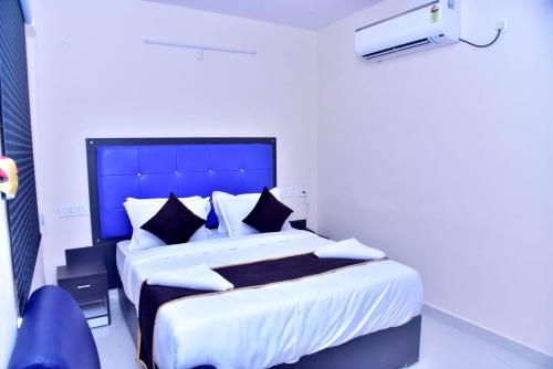 een slaapkamer met een groot bed met een blauw hoofdeinde bij HOTEL PEACOCK INN 