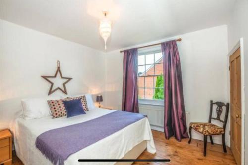 1 dormitorio con cama, ventana y silla en Beautiful cottage near London, en Maidenhead
