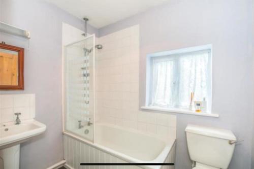 baño con aseo y lavabo y ventana en Beautiful cottage near London, en Maidenhead