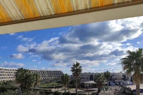 a view of palm trees and a building at Appartement 204, Natura Beach au village naturiste in Cap d'Agde