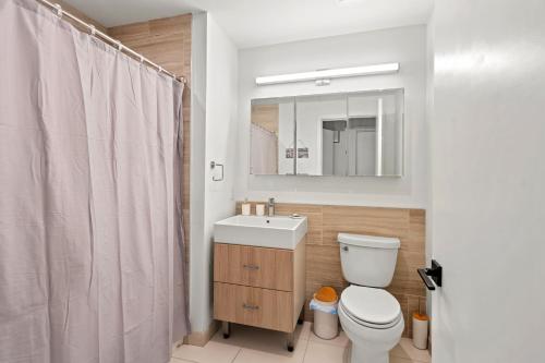 a bathroom with a toilet and a sink and a mirror at Stylish & Chic Experience in JC in Jersey City