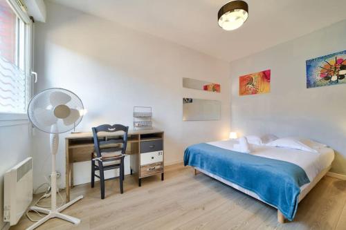 1 dormitorio con cama, escritorio y silla en Cosy apartment 10min from the metro Parking, en Lille