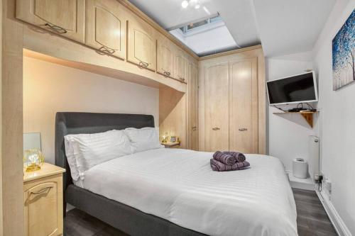 a bedroom with a large white bed with a television at Luxury Oasis in London