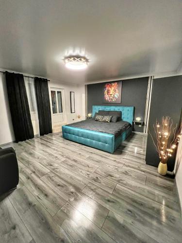 a bedroom with a blue bed in a room at Luxor - Jacuzzi&Cozy Apartments in Sibiu