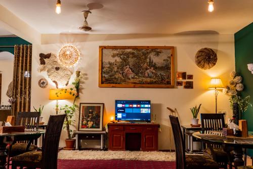 Duroyou Inn في غيلغيت: غرفة معيشة مع تلفزيون وطاولات وكراسي
