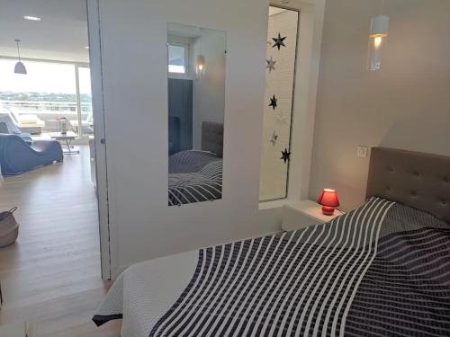 une chambre avec un lit et un miroir au mur dans l'établissement Appartement 323, Port Ambonne, au Cap d'Agde