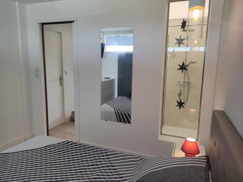une chambre avec un miroir et un lit dans une pièce dans l'établissement Appartement 323, Port Ambonne, au Cap d'Agde