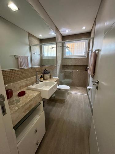 a bathroom with a sink and a toilet at Suite em linda casa em Jurerê internacional in Florianópolis