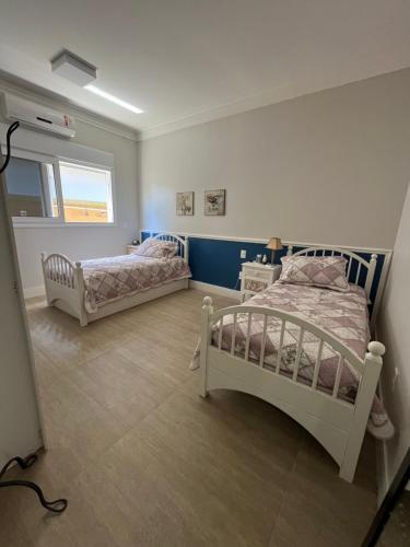 1 dormitorio con 2 camas y ventana en Suite em linda casa em Jurerê internacional en Florianópolis