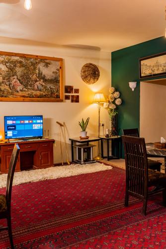a living room with a television and a table and chairs at Duroyo hotel in Gilgit