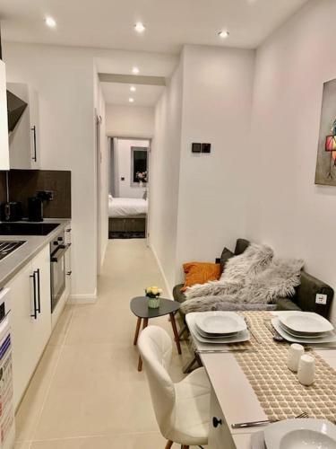 a kitchen and a living room with a table at Annex A, a one bedroom Flat in south London in Carshalton