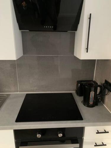 a kitchen counter top with a stove top oven at Annex A, a one bedroom Flat in south London in Carshalton
