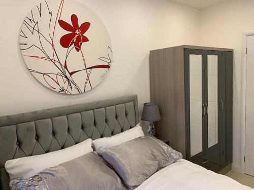 ein Schlafzimmer mit einem großen Spiegel über einem Bett in der Unterkunft Annex A, a one bedroom Flat in south London in Carshalton