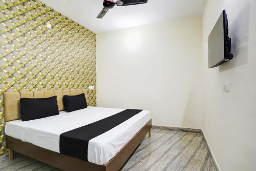 - une chambre avec un lit et une télévision murale dans l'établissement OYO Flagship Hotel Blue Diamond, à Ghaziabad