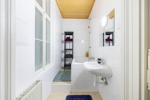 a white bathroom with a sink and a window at Charming spacious apartment in Vienna