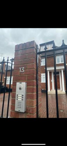 a brick building with a pay phone on a fence at Hendon Escape Luxury Apartment with En-suite Bath in Hendon
