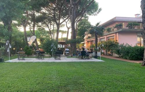 a park with chairs and tables and a building at Storyville Simple Stay in Cinquale