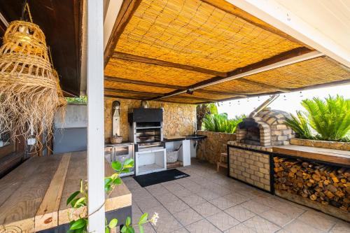 an outdoor kitchen with an open roof with a grill at Casa Picota in Boliqueime