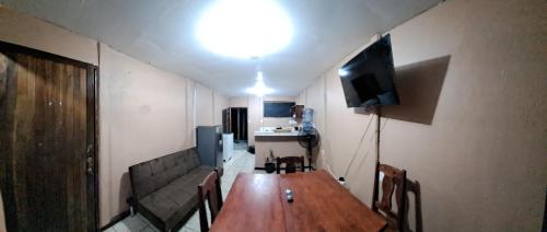 um quarto com uma mesa, um sofá e uma televisão em BRIKE Apartamento em Puerto Jiménez