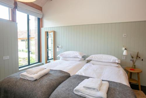 duas camas num quarto com toalhas em Lynchets em Dorchester