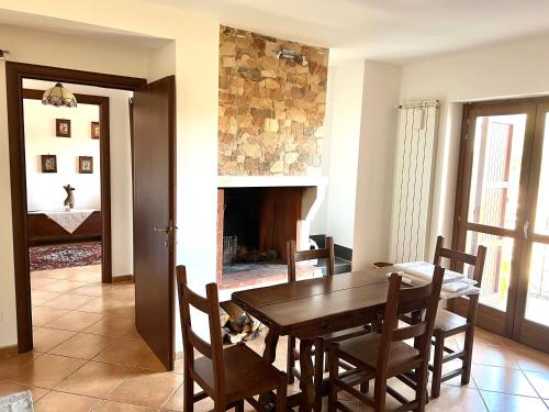 Casa vacanze Borgo Rondini في روكا دي كامبيو: غرفة طعام مع طاولة وكراسي ومدفأة