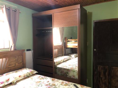 a bedroom with two beds and a large mirror at CASA DE FÉRIAS BH in Belo Horizonte