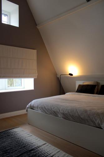 a bedroom with a bed and a window at Un Toit sur les Monts in Esneux