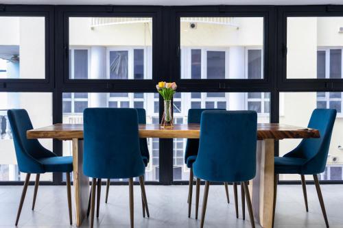 a dining room with a wooden table and blue chairs at Handelskade Penthouse in Willemstad