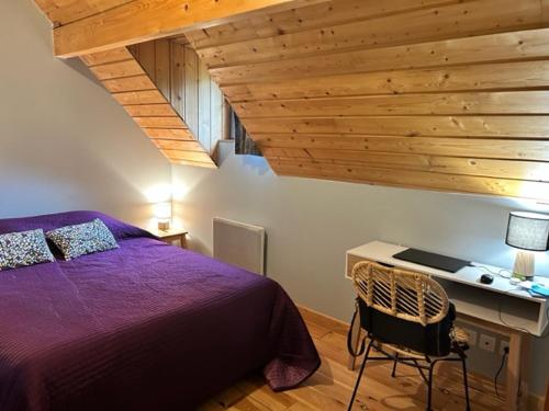 a bedroom with a purple bed and a desk at LES CHALETS D'AURE. in Aragnouet
