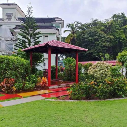 - un kiosque rouge au milieu d'un jardin dans l'établissement Mint Villa, Benaulim, Goa, à Benaulim