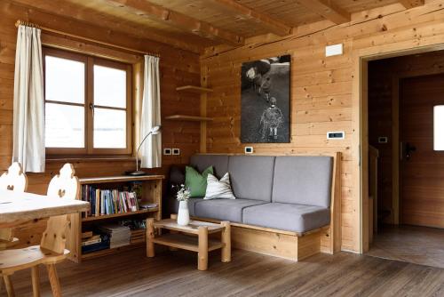 a living room with a couch in a wooden cabin at Unterplattnerhof in Chiusa