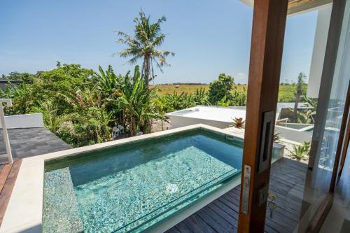 a swimming pool on the balcony of a house at Pagi Villas by Betterplace in Canggu