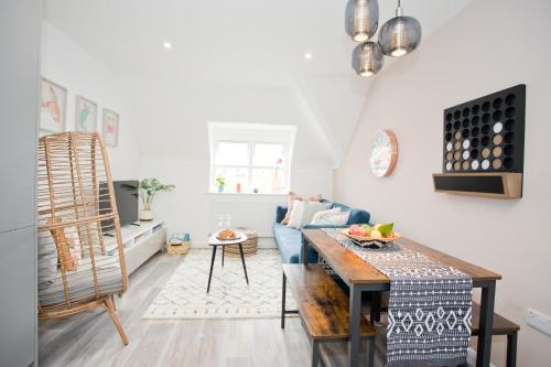 een woonkamer met een blauwe bank en een tafel bij Stylish 2 Bedroom Apt - Parking - 5 Mins walk to Beach in Bournemouth