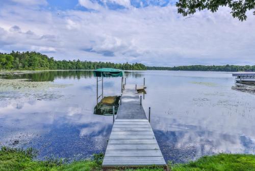 a dock with a boat on a lake at Upper Gresham Lakehouse in Manitowish Waters